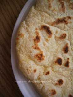 three flat breads on a plate sitting on a table