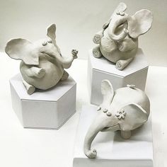 three white ceramic elephants sitting on top of each other's heads in different positions