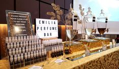 a table topped with lots of different types of bottles and glasses next to a projector screen