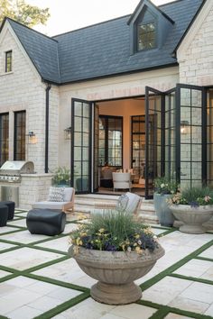 an outdoor living area with potted plants and chairs in front of the patio door