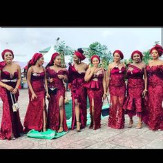 a group of women in red dresses standing next to each other on a brick floor