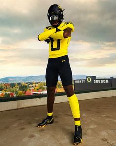 a man in a yellow and black football uniform is holding his hands on his hips