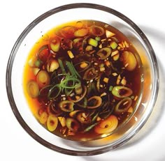 a glass bowl filled with food on top of a white table