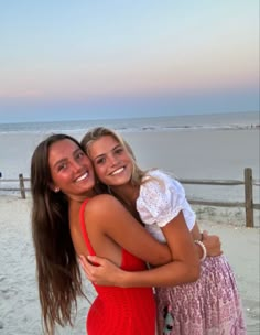 two women hugging each other on the beach