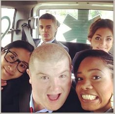 a group of people are posing in the back of a car for a photo together