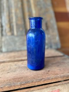 a blue vase sitting on top of a wooden table