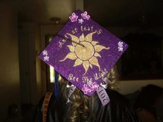 a purple and gold graduation cap with the sun on it