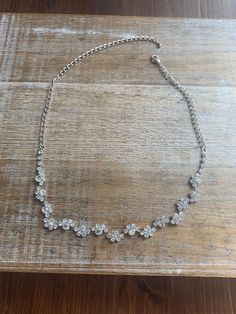 a silver necklace on a wooden table