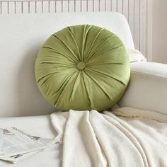 a green pillow sitting on top of a white couch