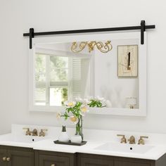 a bathroom vanity with two sinks and a large mirror above it, along with a gold chandelier