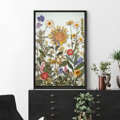 a living room with a black chair and flowers on the wall in front of it