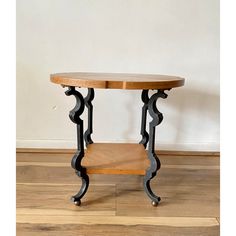 a wooden table sitting on top of a hard wood floor next to a white wall