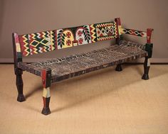 a bench made out of woven material and wooden legs with designs on the backrest