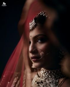 a woman wearing a veil and headpiece in an artistic fashion photo with her hands behind her head