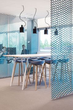 an office with blue walls and chairs in front of a table that has been partitioned into the wall