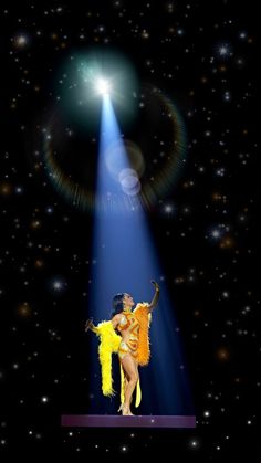 a woman is performing on stage in front of a bright light and some stars behind her