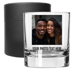 a personalized shot glass next to a black candle holder with a photo on it