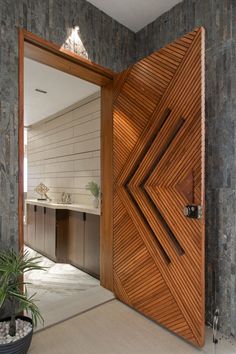 an open door leading into a bathroom with a plant in the foreground and a sink on the other side