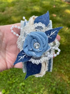 a hand holding a blue and white flower on top of it's headband