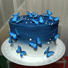 a cake with blue butterflies on it sitting on a plate