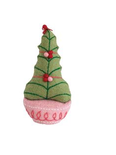 a green christmas tree sitting on top of a pink cupcake