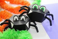 two black and green paper spider decorations on a table