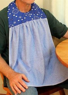 a man sitting at a table with an apron on