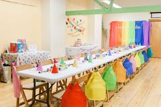 a room filled with lots of tables and chairs covered in colorful hats on top of them