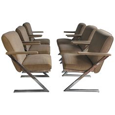 a set of six chairs with metal legs and arms, all in beige upholstered fabric