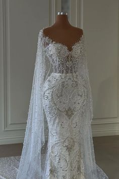 a wedding dress on display in front of a mannequin's headdress