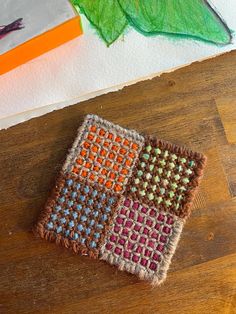 two pieces of crocheted cloth sitting on top of a wooden table