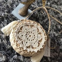 a small round bag with tassels on top of it sitting on a carpet