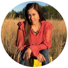 a woman is sitting in the middle of a field