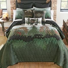 a bed covered in a green and black comforter next to a brick headboard