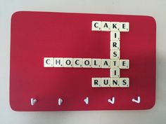 scrabble tiles spelling out the words cake, iris, chocolate, runs on a red place mat