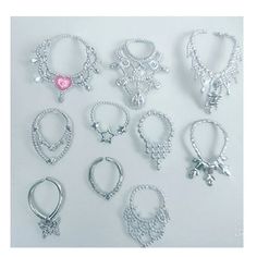 many different types of bracelets on a white surface with one pink heart in the middle