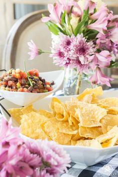 a table topped with bowls filled with food next to flowers