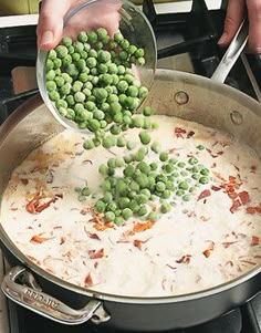 peas being cooked in a large pot on the stove with someone's hands reaching for them