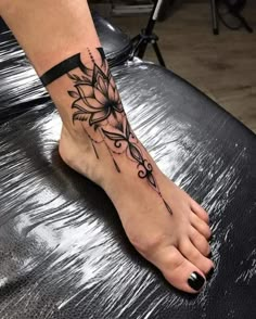 a woman's foot with a flower tattoo on it