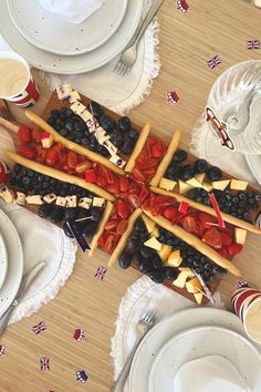 a wooden table topped with cheese sticks and fruit