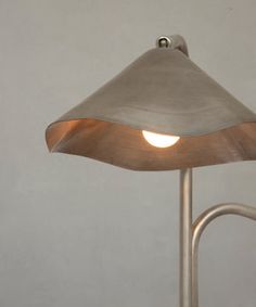 a lamp that is sitting on top of a metal pole with a light bulb in the middle