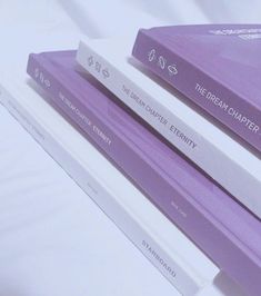 two purple books sitting on top of each other