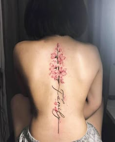 the back of a woman's neck with flowers on it and her name written in cursive writing