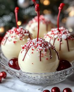 three white chocolate truffles with red and white sprinkles in a glass bowl