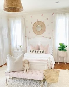 a white bed sitting in a bedroom next to a window with pink polka dots on it