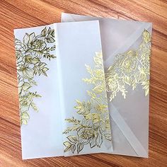 two envelopes with gold foil designs on them