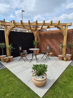 an outdoor patio with potted plants on the ground and wooden pergolan arbor