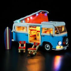 a blue and white bus parked next to a surfboard on top of a table