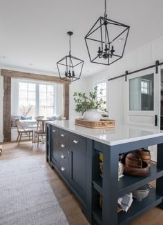 a large kitchen island with lots of counter space and hanging lights over it's top