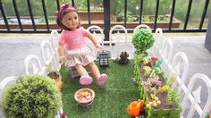 a doll sitting on top of a chair next to a garden